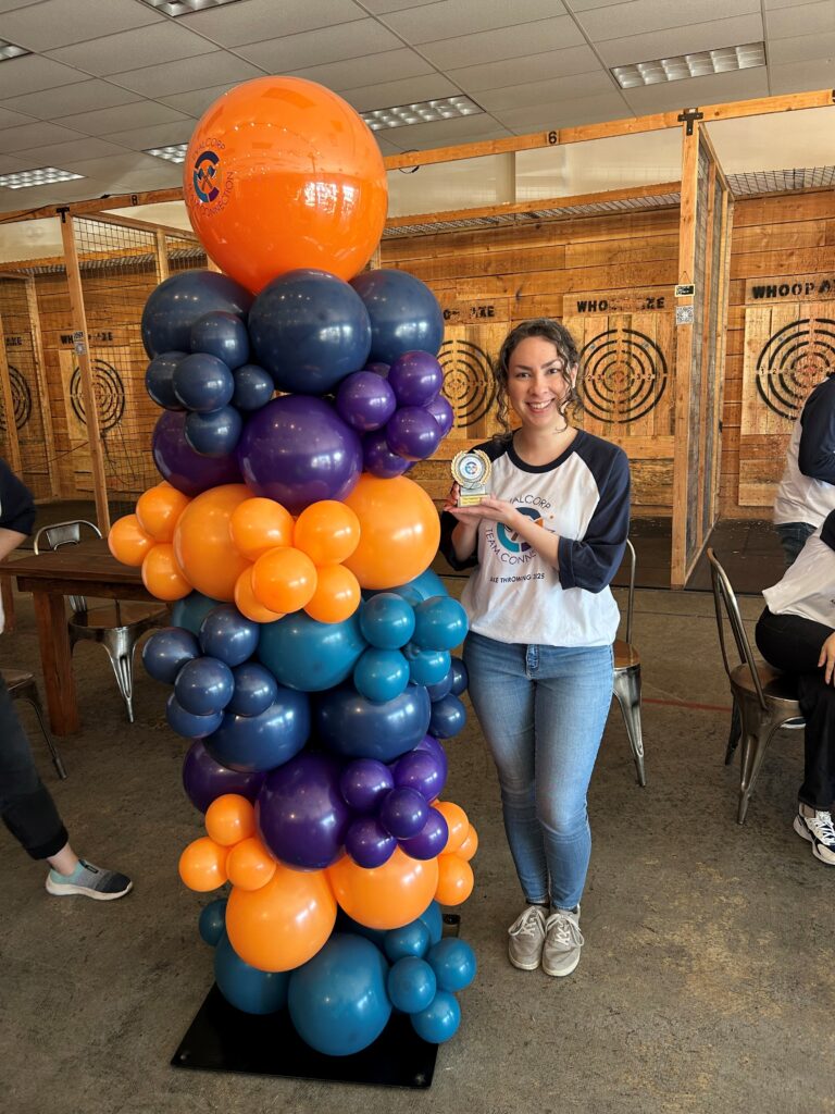 Taylor smiles with her trophy next to the balloon arch