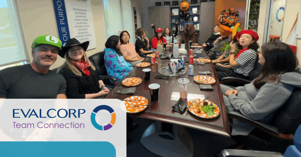 Picture of the EVALCORP Halloween party — features team members in the conference room in Halloween costumes