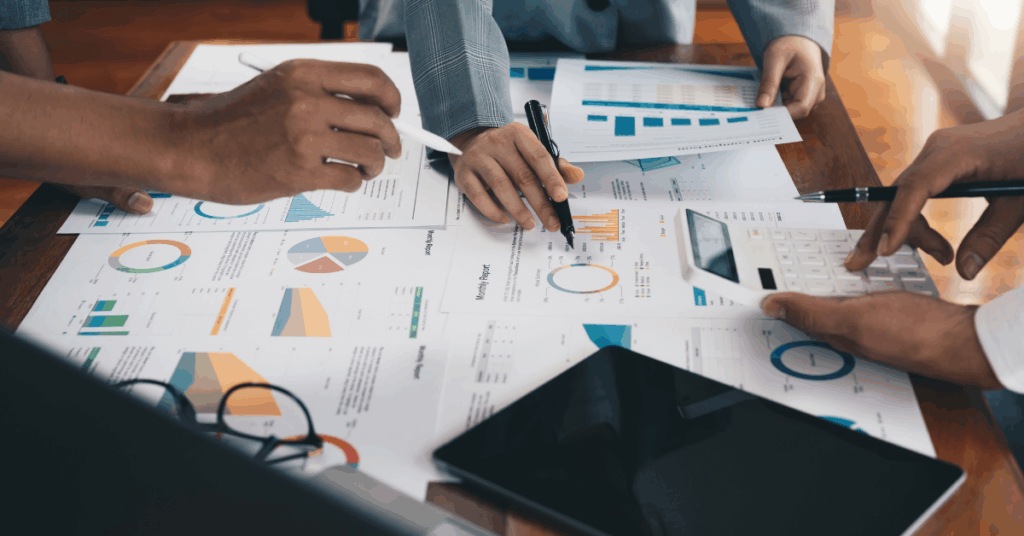 Decorative image of hands over documents with charts and graphs