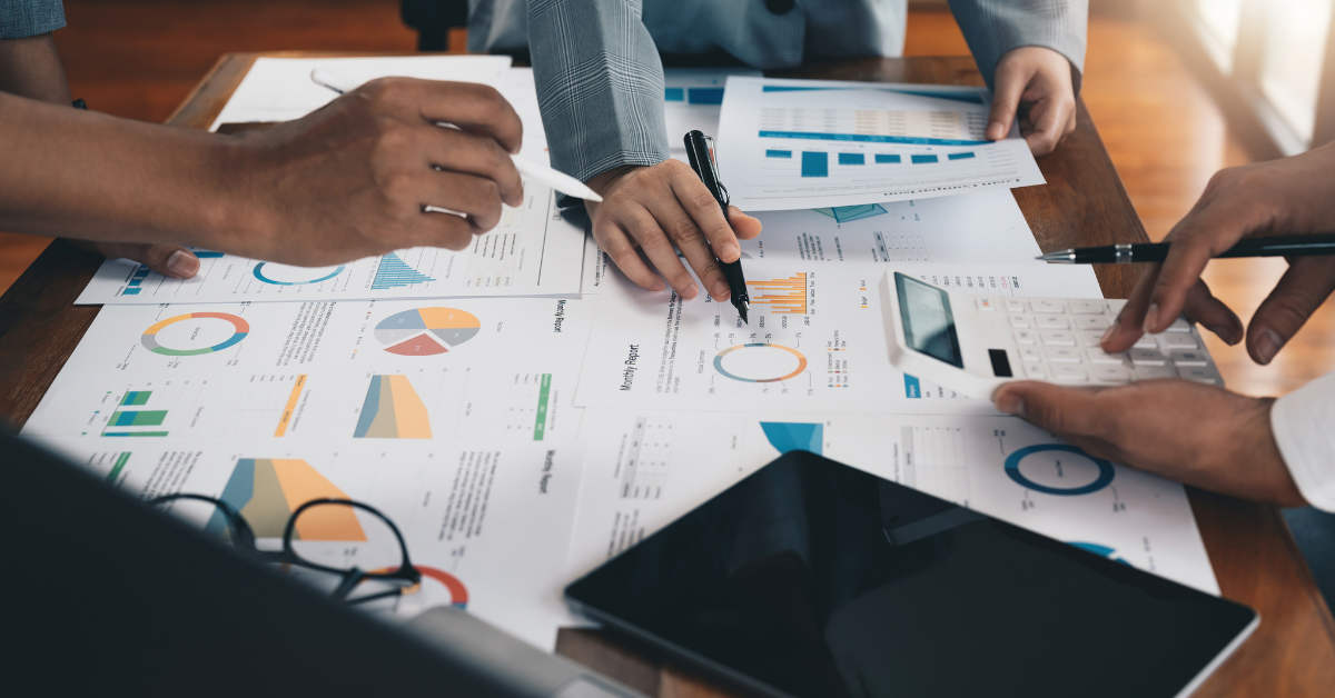 Decorative image of hands over documents with charts and graphs