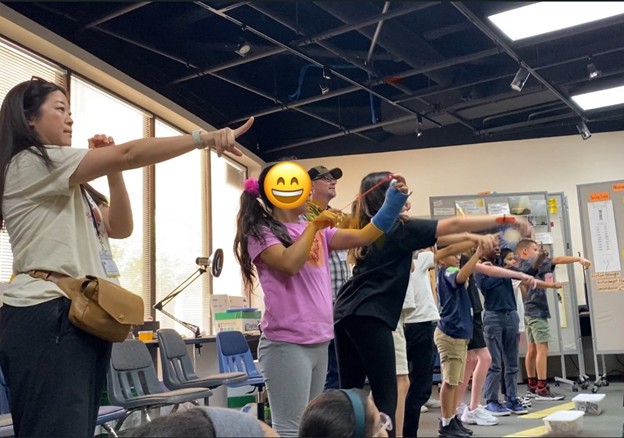 Celina demonstrating tension force alongside students